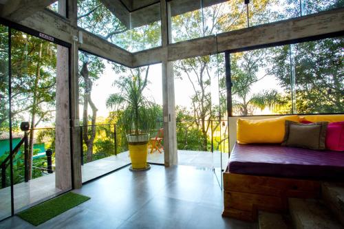 a room with a bed in a house with windows at Casas Temporada Aldeia Niura Opy in Florianópolis