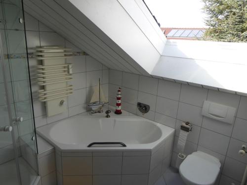 a bathroom with a sink and a toilet and a skylight at Ferienwohnung Bodenseeblick in Nonnenhorn