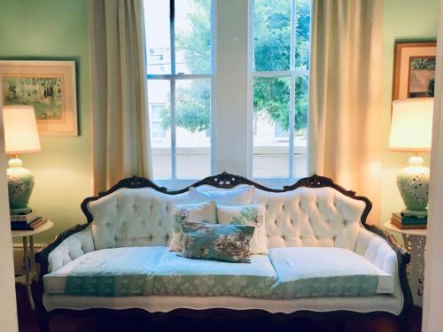 a white couch in a room with a window at DOLLHOUSE, 6 BR, French Quarter, JAZZ FEST sleeps 13! in New Orleans