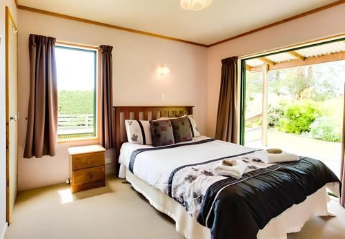 a bedroom with a bed and a large window at Havelock North Holiday Park in Havelock North