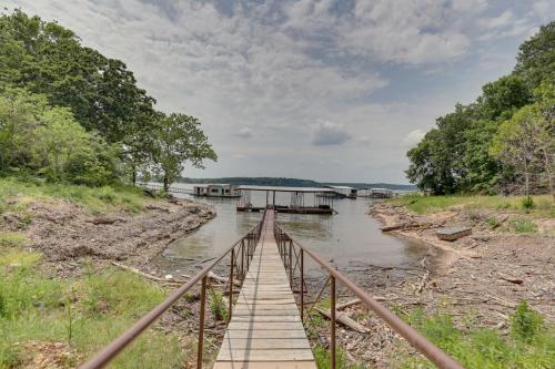 a wooden bridge over a river with two boats at Dock and Pool Access Lakefront Grove Home! in Grove