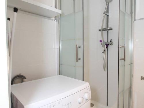 La petite salle de bains est pourvue d'une douche et d'un lave-linge. dans l'établissement Studio 2 places avec climatisation et wifi à Balaruc-les-Bains - FR-1-553-111, à Balaruc-les-Bains