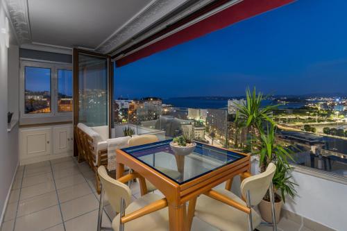a balcony with a glass table and chairs at El Balcón de Charles in Santander