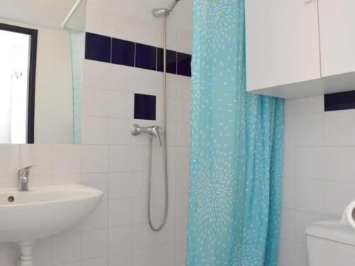 baño con cortina de ducha azul y lavamanos en Maison Narbonne, 2 pièces, 4 personnes - FR-1-229B-39, en Narbona