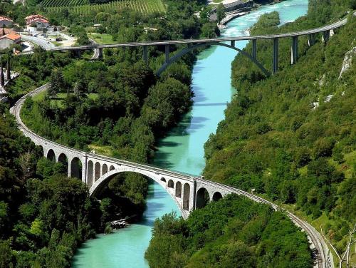 a bridge over a river with green water at Pri Piskovih in Grgar