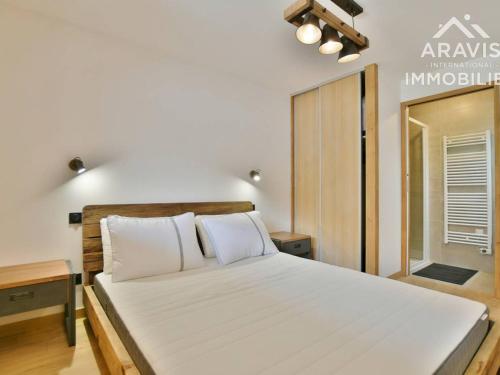 een slaapkamer met een groot bed met witte lakens bij Appartement Le Grand-Bornand, 3 pièces, 4 personnes - FR-1-391-118 in Le Grand-Bornand