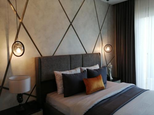 a bedroom with a bed with two lights on it at Family Apartment with pool Eden Valley in Alanya