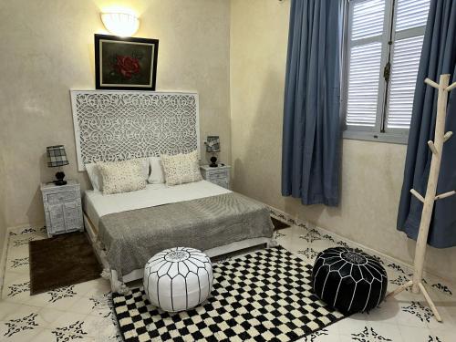 a bedroom with a bed and a black and white floor at Oasis Merasi Marrakech in Marrakech