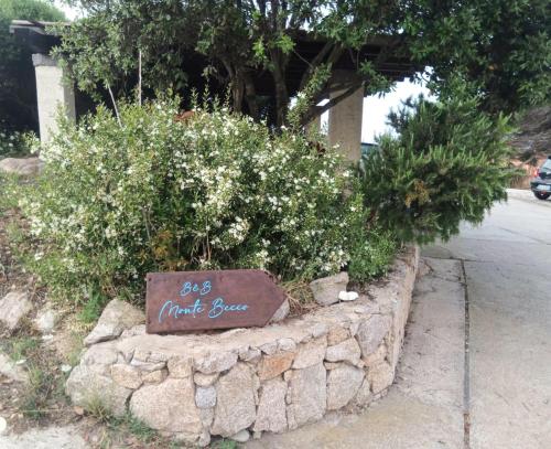 a sign that says first beer in a stone wall at Monte Becco panoramic rooms in Santa Teresa Gallura