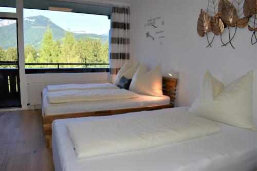 two beds in a room with a large window at Apartment d ´Freizeit in Bad Goisern