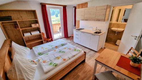 Habitación pequeña con cama y cocina en Gästehaus Landhaus Tyrol, en Gries im Sellrain