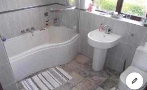 a bathroom with a sink and a tub and a toilet at Rode house home stay in Rode Heath