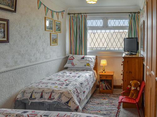 a bedroom with a bed and a chair and a window at Josies Den in Bridlington