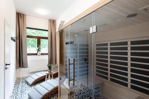 uma casa de banho com uma cabina de duche em vidro e 2 almofadas. em Penzion Mezi buky em Chribská