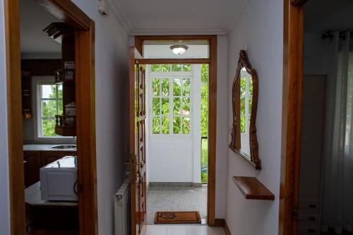 a hallway with a door and a kitchen with at Casa Rural Fidalgo in Chantada