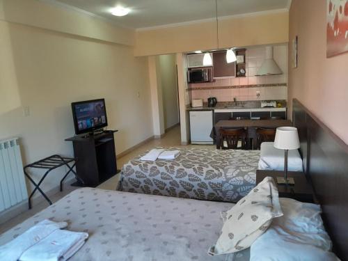 um quarto de hotel com duas camas e uma cozinha em Antares Apartments em Campana