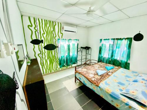 a bedroom with a bed and a green wall at Padang Besar Homestay Firdaus in Padang Besar