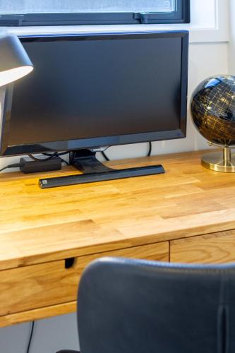 a computer monitor sitting on top of a wooden desk at Modern 3 bed overlooking Hagley Park in Christchurch
