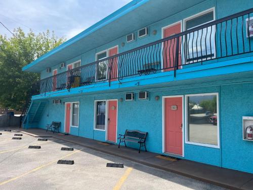 a blue building with red doors and a balcony at Lakeside Villa in Penticton