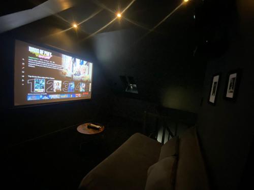 una camera con TV e divano in una camera oscura di CASA DOLCE ad Amiens