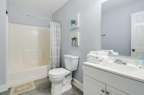 a white bathroom with a toilet and a sink at Summertime Escape with Grill Walk to Atlantic Beach in Myrtle Beach