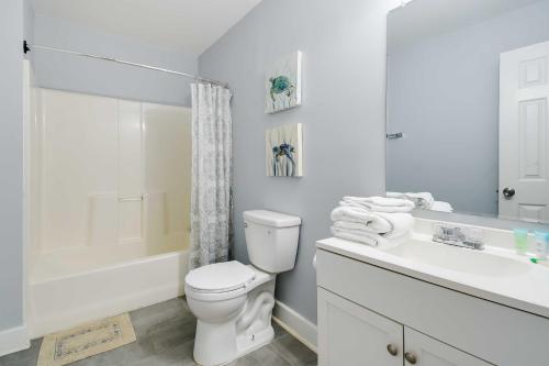 a white bathroom with a toilet and a sink at Walk to Atlantic Beach Family Gem with Fenced Yard in Myrtle Beach