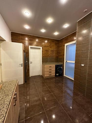eine Küche mit einem Kühlschrank und Fliesenboden in der Unterkunft Luxurious & Charming Villa in Sheikh Zayed