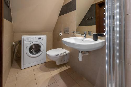 a bathroom with a washing machine and a sink at Liliowe Turnie, Zakopane centrum, garaż podziemny in Zakopane