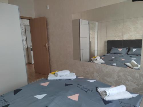 um quarto com um espelho e uma cama com toalhas em Grand apartman em Belgrado
