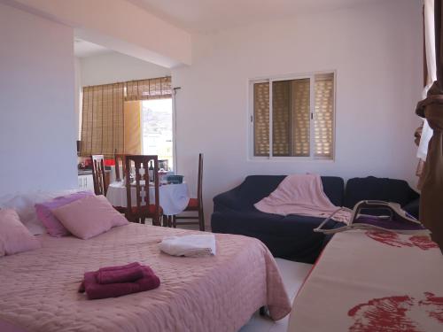 1 Schlafzimmer mit 2 Betten und einem Sofa in der Unterkunft Casa de Nômades Digitais in Mindelo