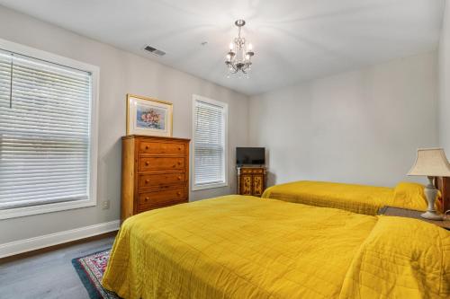 a bedroom with two beds and a dresser and windows at Golfer's Delight at World Tour Golf in Myrtle Beach