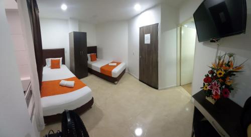 pokój hotelowy z 2 łóżkami i telewizorem w obiekcie HOTEL RAI MEDELLIN w mieście Medellín