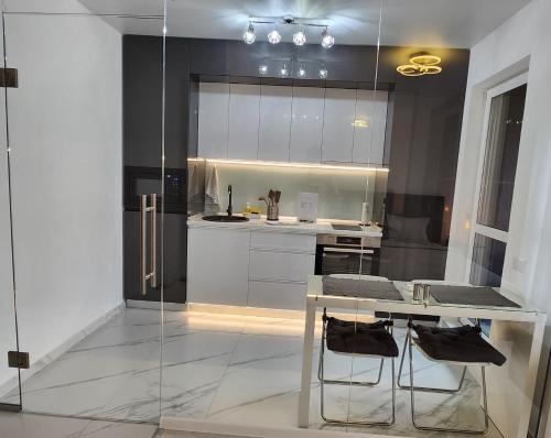 Chiajna的住宿－Elite Studio Militari Residence，厨房配有桌子和玻璃墙