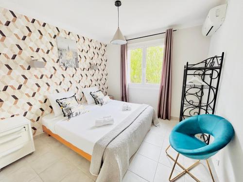 um quarto com uma cama e uma cadeira azul em 2 bedroom luxury flat with Balcony Cannes Center em Cannes