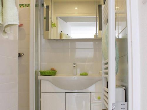 une salle de bain blanche avec un lavabo et un miroir dans l'établissement Superbe T2 climatisé à 50m de la plage, piscine, parking, 5 pers - FR-1-607-97, au Cap d'Agde