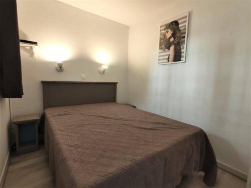 une chambre avec un lit et un tableau au mur dans l'établissement Appartement 3P Cannes la Bocca avec terrasse, piscines et parking à 200m de la plage - FR-1-609-15, à Cannes