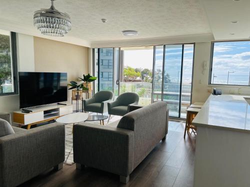 a living room with couches and a flat screen tv at Berkeley on the Beach in Gold Coast