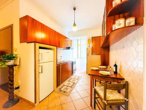 a kitchen with a table and a white refrigerator at Giardino degli Aranci Lulus Home in Rome