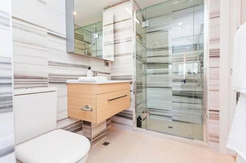 a bathroom with a shower and a toilet and a sink at Spacious one bedroom apartment in Newmarket in Auckland