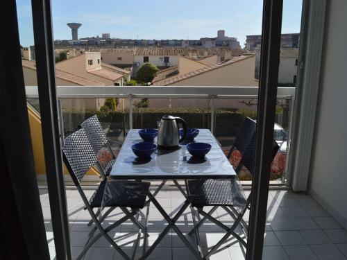 - un balcon avec une table et des chaises et une bouilloire dans l'établissement Studio climatisé 4 couchages proche plage et commerces au Grau-du-Roi - FR-1-250-160, au Grau-du-Roi