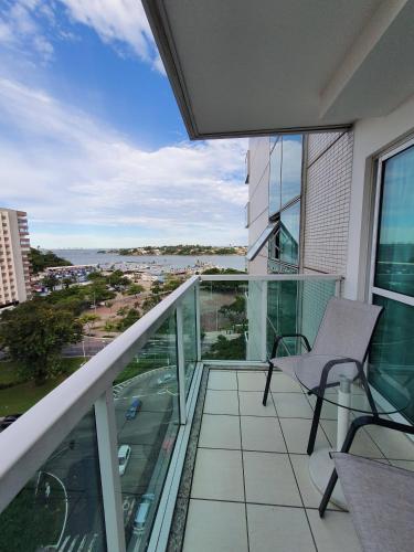 a balcony with a chair and a view of the water at Praia do canto apart 3 in Vitória