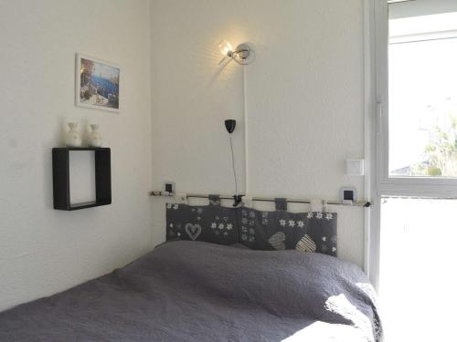 une chambre avec un lit avec une tête de lit noire et une fenêtre dans l'établissement Studio cabine 4 pers, Cap d'Agde, proche port - FR-1-249-360, au Cap d'Agde