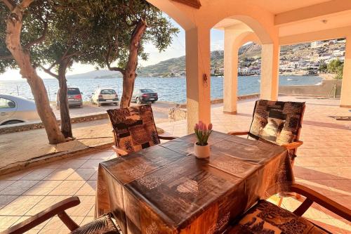 een tafel en stoelen op een veranda met uitzicht op het water bij Apartments by the sea Metajna, Pag - 6465 in Metajna