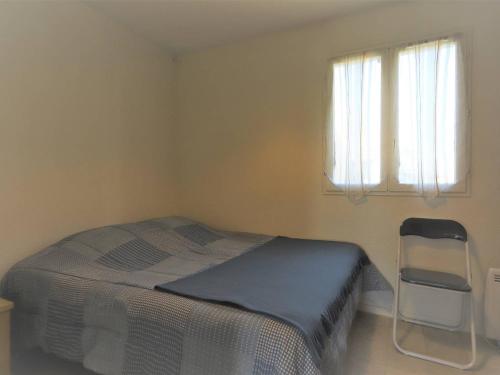 une chambre avec un lit, une chaise et une fenêtre dans l'établissement Beau 2 pièces pour 5 pers. avec parking, piscine et loggia, à 400m de la plage à Palavas - FR-1-559-14, à Palavas-les-Flots