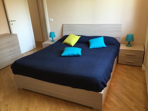 a bedroom with a large bed with blue and yellow pillows at Luxury Villa Park in Nepi