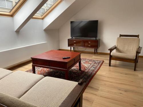 uma sala de estar com um sofá e uma televisão de ecrã plano em Spacious app/Antwerp city center #003 em Antuérpia