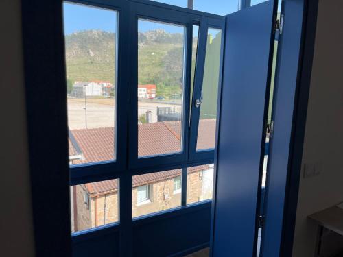 an open window with a view of a building at O Refuxio do Náufrago in Camelle