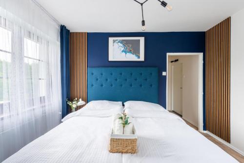 a blue bedroom with a bed with a basket on it at Penzion Mezi buky in Chřibská