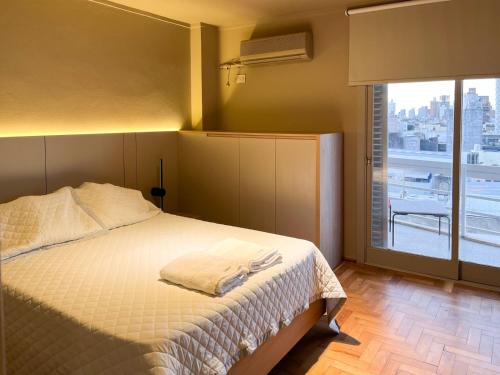 1 dormitorio con cama y ventana grande en Departamento CENTRICO de dos dormitorios - EVA PERÓN en Santa Fe