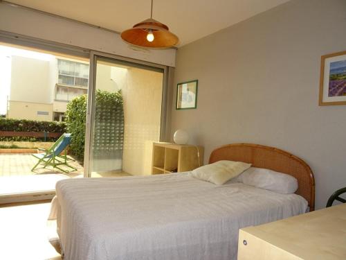 une chambre avec un lit et une porte coulissante en verre dans l'établissement T2 cabine à Palavas avec piscine, plage et parking, 6 personnes - FR-1-559-18, à Palavas-les-Flots